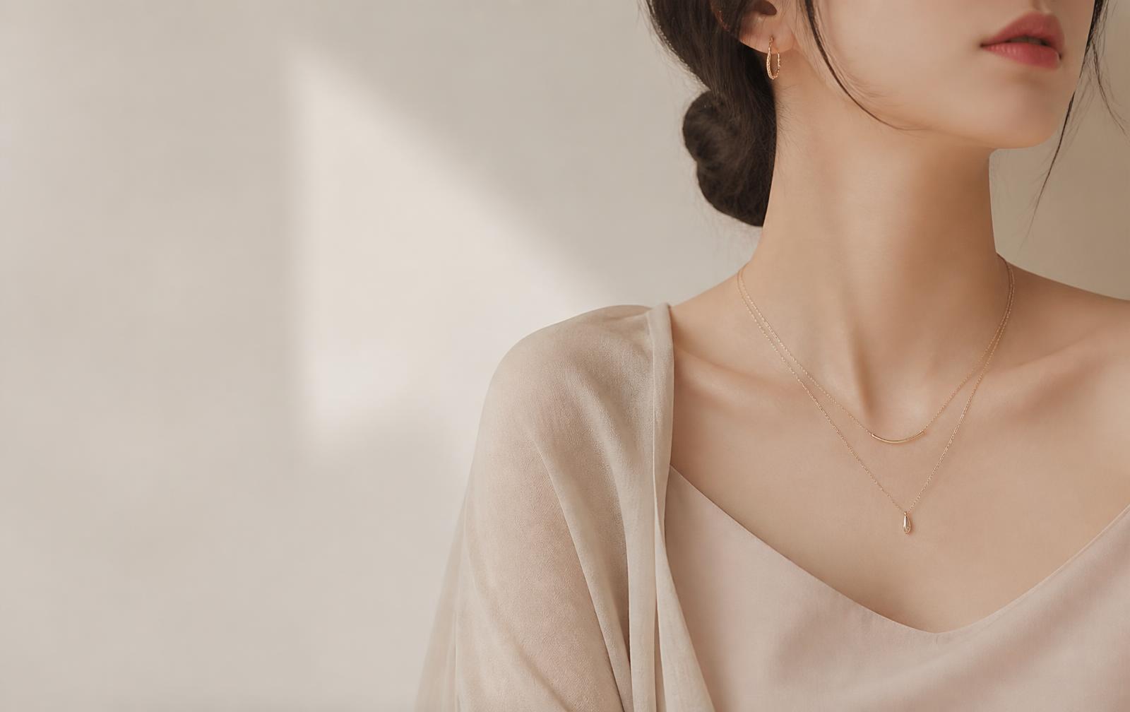Dainty layered gold necklaces on a model